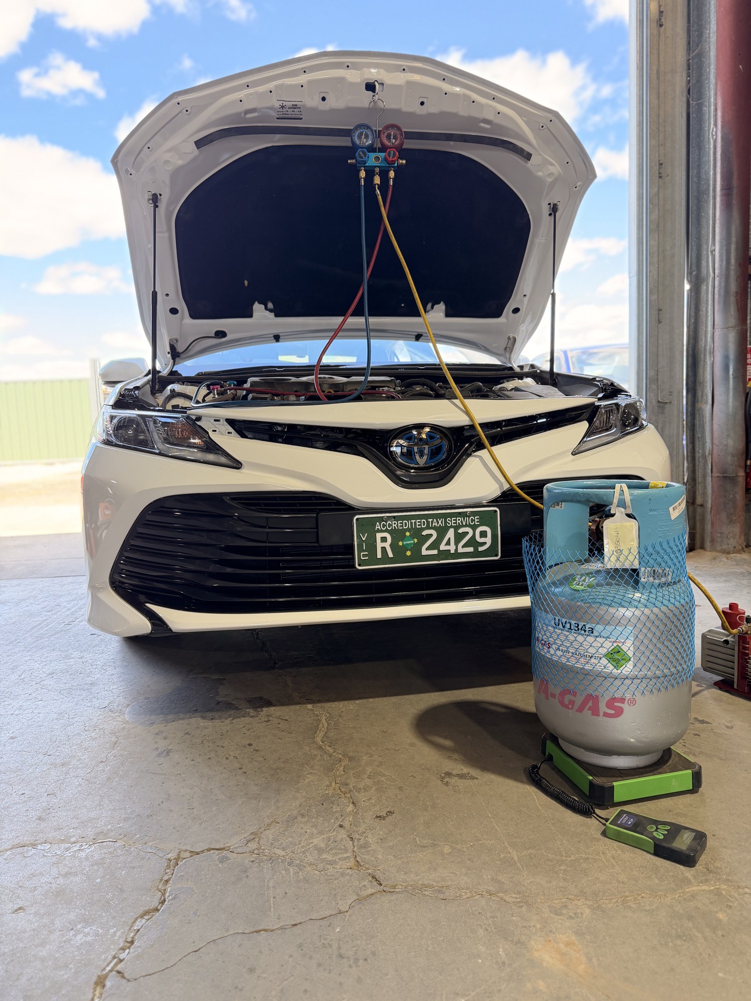 Cleretec Automotive air conditioning regas equipment connected to an engine bay